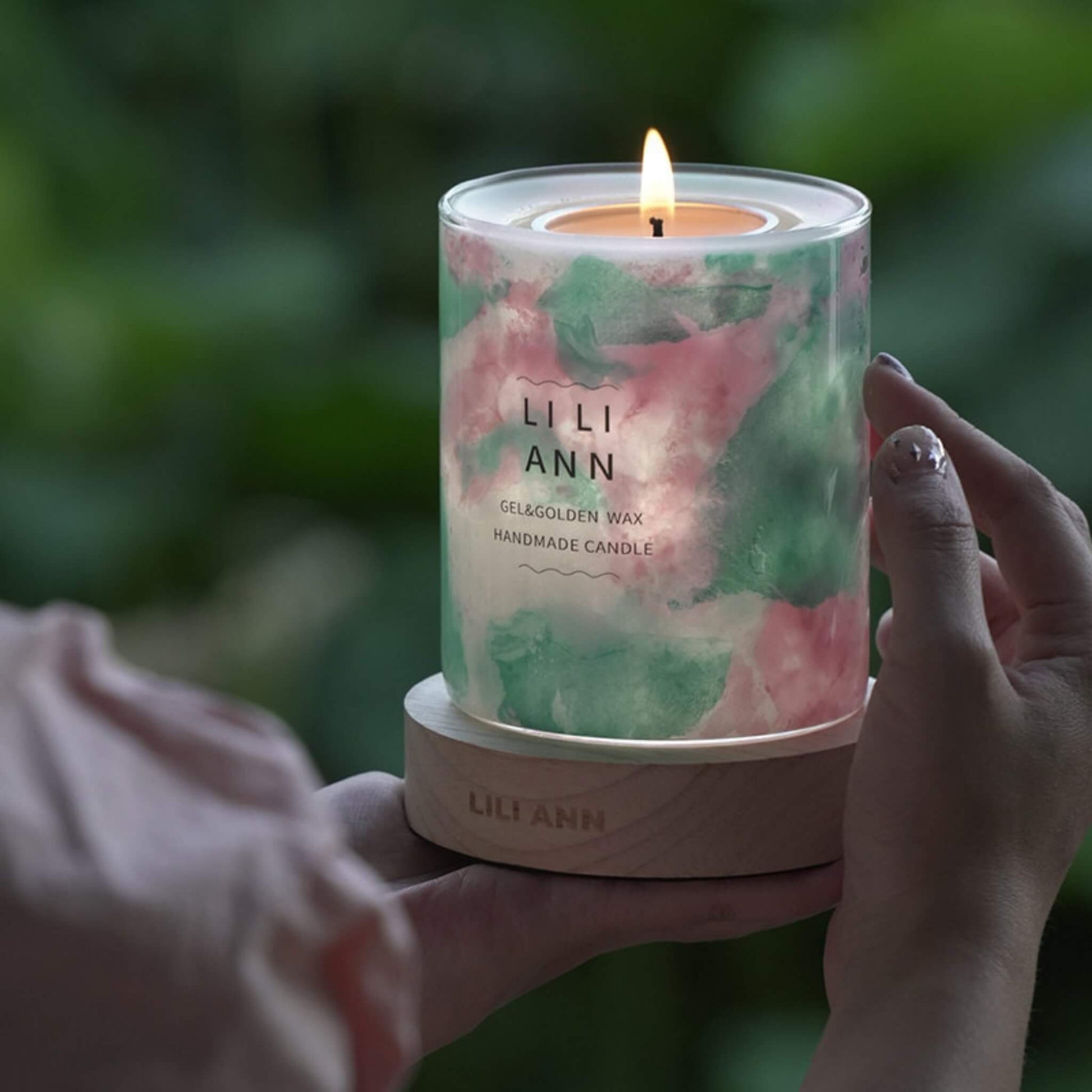 Hands holding the lit Serene Vessel, highlighting the calming pastel colors and gel texture.