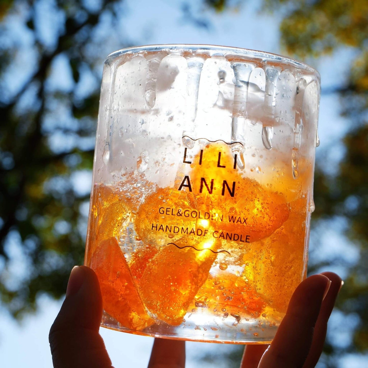 Hand holding Object .16 Solar under bright sunlight, showing the translucent orange gel and bubbles.